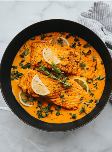 Coconut curry salmon meal sitting in a cast iron skillet.